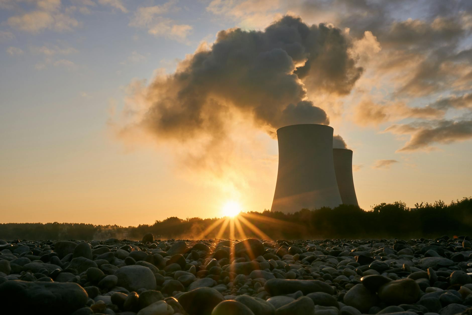 low angle photo of nuclear power plant buildings emtting smoke